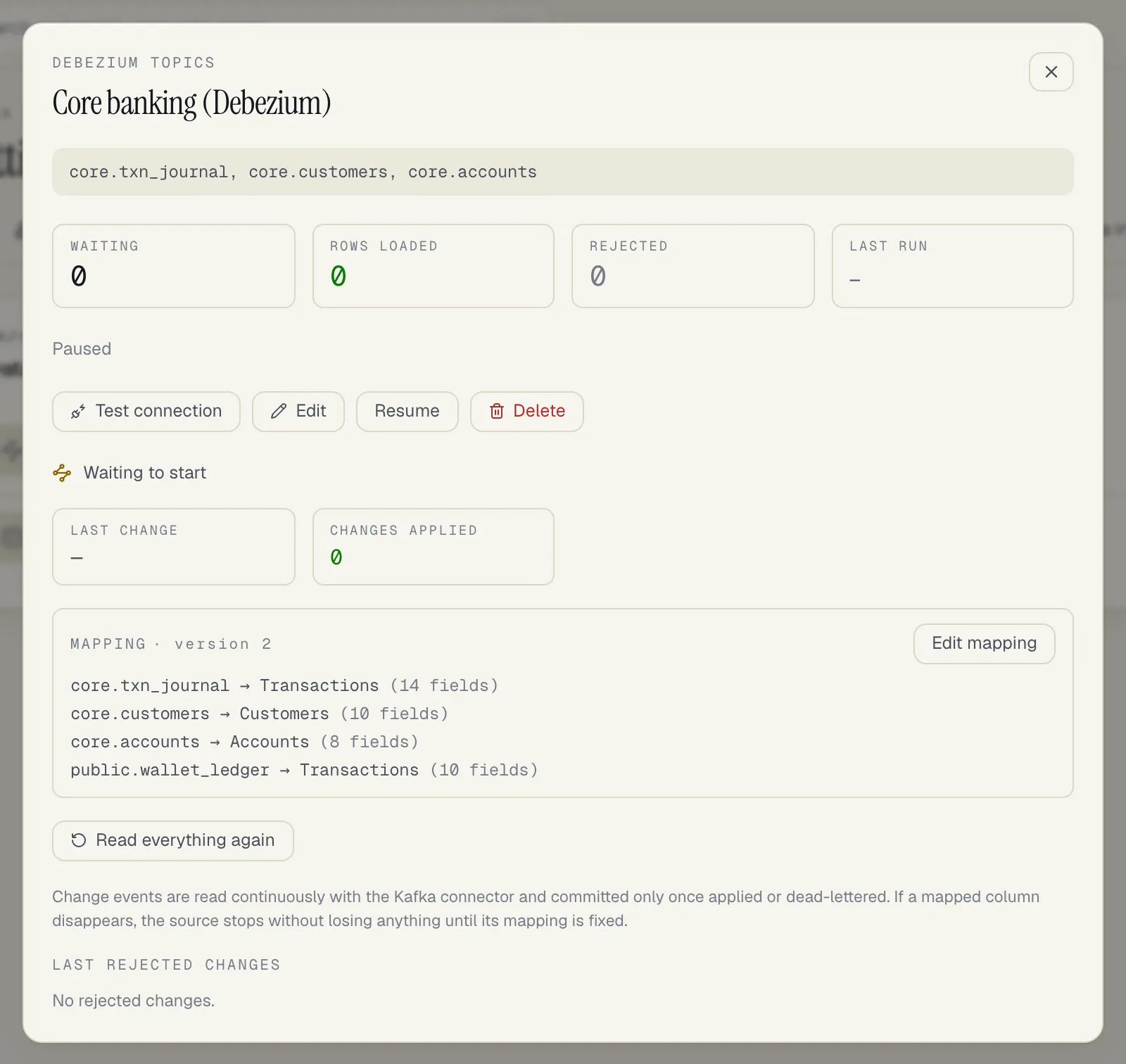 A paused Debezium topics source: Waiting to start, Last change and Changes applied tiles, Mapping version 2 listing core.txn_journal to Transactions (14 fields), core.customers to Customers, core.accounts to Accounts and public.wallet_ledger to Transactions, with Edit mapping and Read everything again