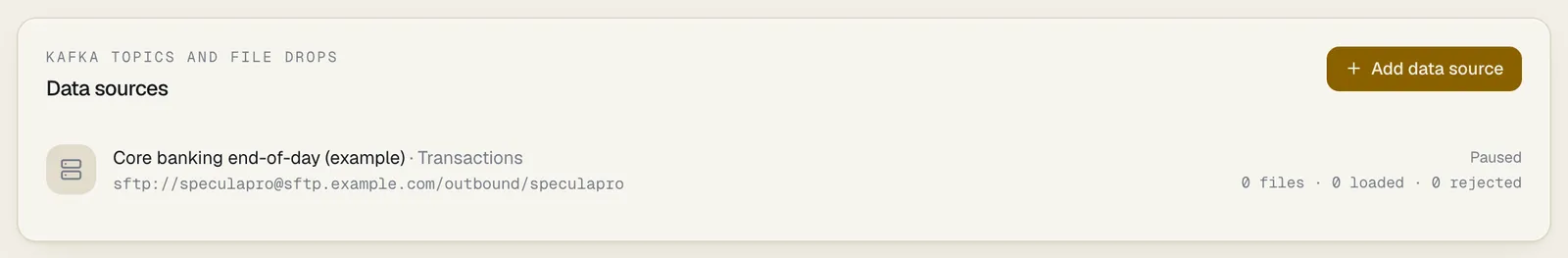 The Data sources panel listing one paused SFTP source, Core banking end-of-day (example), carrying transactions, with its address and 0 files, 0 loaded, 0 rejected